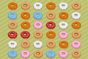 Barevné donuty s polevou a posypem uspořádané v mřížce na zeleném pozadí