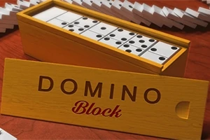 Dřevěná krabička s dominovými kameny na červeném povrchu, s nápisem DOMINO Block na víku