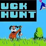 Pes držící ulovenou kachnu stojí v trávě s nápisem DUCK HUNT nad ním na modré obloze