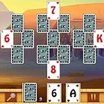 Karty uspořádané do tvaru kříže na pozadí egyptské pouště s pyramidami a sochami