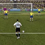 Fotbalista v bílo-černém dresu se připravuje kopnout penaltu proti brankáři a obraně ve žlutých dresech stojících před bránou