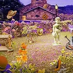 Zahrada s sochou dítěte, kamenným domem v pozadí, květinami a různými předměty jako klobouk a konev
