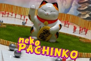 Soška šťastné kočky s jednou zvednutou packou na herní ploše, obklopená malými kuličkami a pestrobarevným nápisem neko PACHINKO