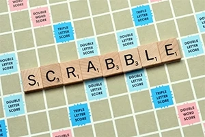 Herní deska s dřevěnými písmeny tvořícími slovo SCRABBLE