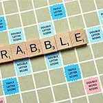 Herní deska s dřevěnými písmeny tvořícími slovo SCRABBLE