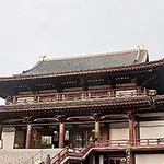 Tradiční japonská dřevěná budova s velkou střechou a schodištěm v popředí