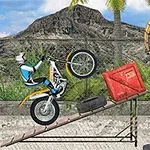 Motocykl jede po nakloněné rampě, obklopené bednami a pneumatikami, v pozadí je plot, hory a palmy